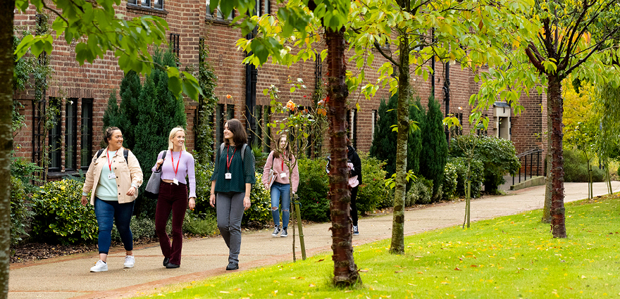 Students waling along the pathway outside of the HCA building